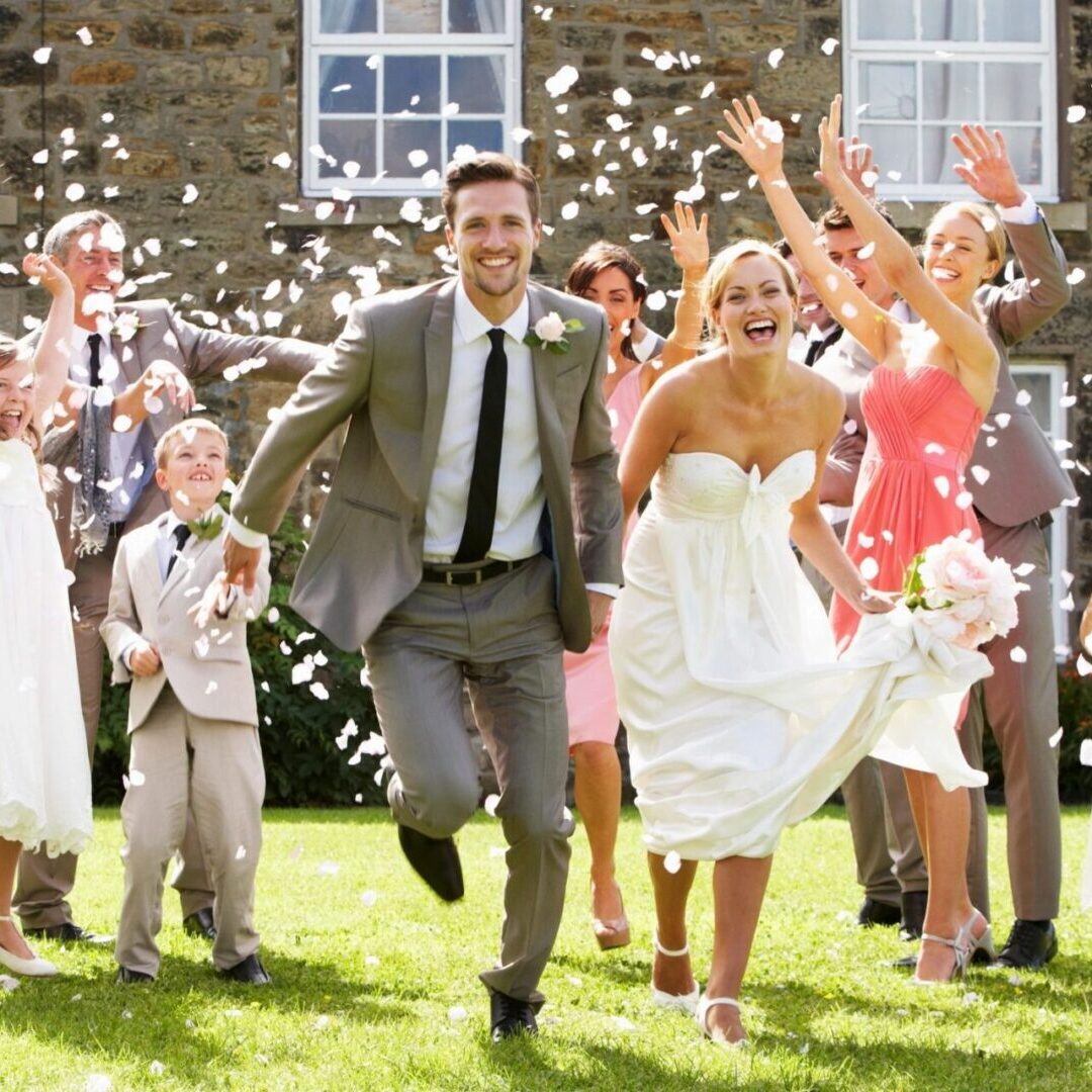 Newlyweds joyfully run through a shower of flower petals after their wedding ceremony.